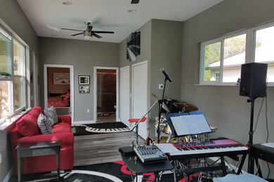 Example of a mid-sized classic open concept medium tone wood floor and gray floor living room design in Tampa with a music area, gray walls, no fireplace and no tv