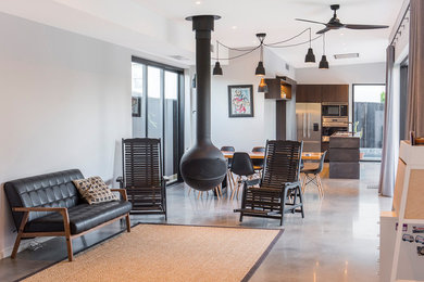 This is an example of a contemporary formal open plan living room in Perth with white walls, a hanging fireplace, a metal fireplace surround, grey floors and concrete flooring.