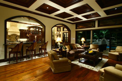 Example of a mid-sized tuscan open concept medium tone wood floor living room design in Miami with white walls