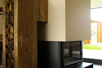 Diseño de salón actual grande con paredes beige y marco de chimenea de yeso