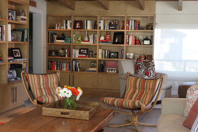 Living room library - mid-sized rustic enclosed medium tone wood floor and brown floor living room library idea in Los Angeles with beige walls
