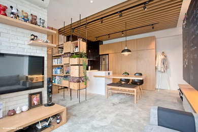 This is an example of a small industrial open plan living room in Hong Kong with white walls, concrete flooring and a wall mounted tv.