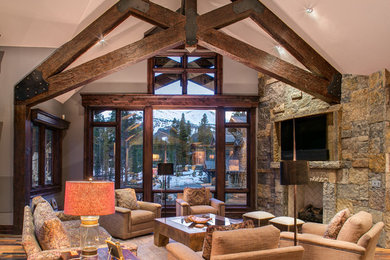 Living room - rustic open concept dark wood floor living room idea in Denver with a standard fireplace, a stone fireplace and a wall-mounted tv