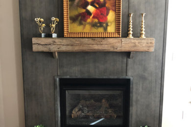 Example of a mid-sized urban formal and enclosed medium tone wood floor and brown floor living room design in Philadelphia with gray walls, a standard fireplace and a metal fireplace