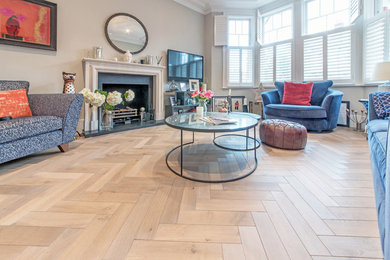 Inspiration for a contemporary living room in London with light hardwood flooring.
