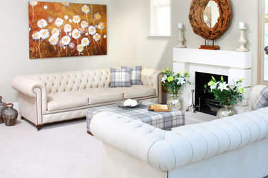 Photo of a large modern formal enclosed living room in London with beige walls, carpet, a standard fireplace, a stone fireplace surround and no tv.