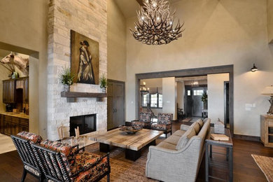 Mid-sized mountain style formal and open concept dark wood floor and brown floor living room photo in Austin with beige walls, a standard fireplace, a stone fireplace and no tv