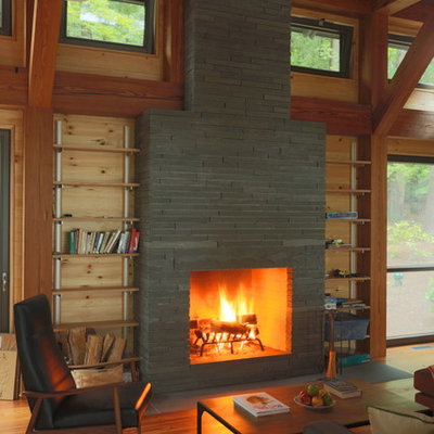 Mountain style dark wood floor living room photo in Boston with a standard fireplace and a stone fireplace