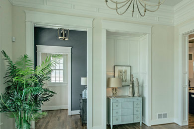 Modelo de salón cerrado clásico renovado de tamaño medio con paredes beige y suelo de madera oscura