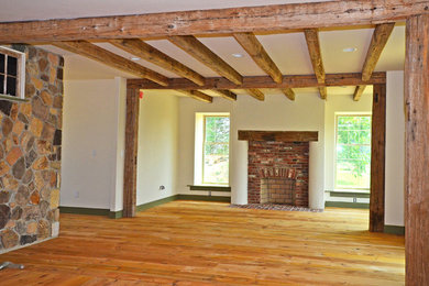 Diseño de salón de estilo de casa de campo con paredes blancas, suelo de madera clara, todas las chimeneas, marco de chimenea de ladrillo y suelo marrón