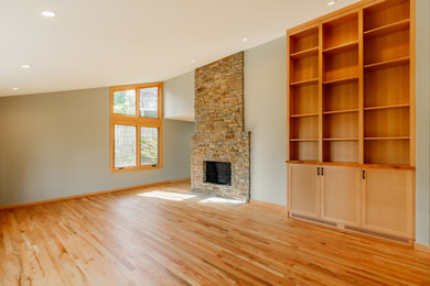 Inspiration for a modern open concept medium tone wood floor and orange floor living room remodel in Seattle with gray walls and a stone fireplace