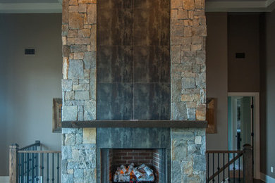 Example of a mid-sized mountain style formal and loft-style dark wood floor living room design in Other with gray walls, a standard fireplace, a stone fireplace and no tv