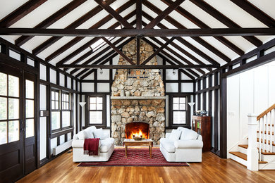 ワシントンD.C.にあるトランジショナルスタイルのおしゃれな応接間 (白い壁、無垢フローリング、標準型暖炉、石材の暖炉まわり、テレビなし、茶色い床) の写真