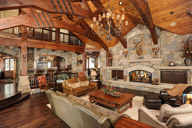 Living room - rustic open concept medium tone wood floor and brown floor living room idea in Denver with beige walls, a standard fireplace, a stone fireplace and no tv