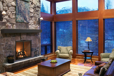 Example of a mid-sized mountain style formal and enclosed dark wood floor living room design in Milwaukee with beige walls, a standard fireplace, a stone fireplace and no tv