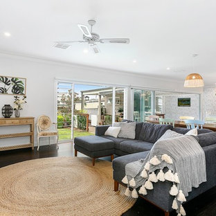 Design ideas for a country open concept living room in Other with white walls, dark hardwood floors, a freestanding tv and brown floor.