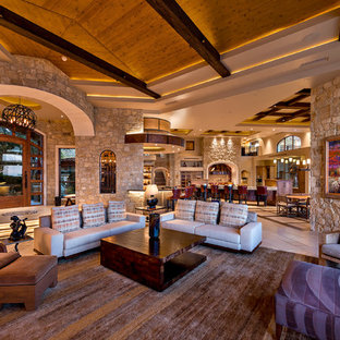Example of a huge trendy open concept travertine floor living room design in Phoenix with a bar, multicolored walls and a media wall