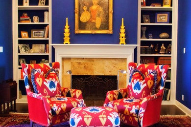 Esempio di un soggiorno eclettico di medie dimensioni con pareti blu, parquet scuro, camino classico, cornice del camino in pietra, nessuna TV, pavimento marrone e libreria