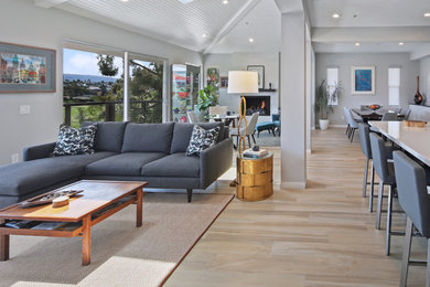 This is an example of a medium sized contemporary open plan living room in Orange County with grey walls, porcelain flooring, a standard fireplace and beige floors.