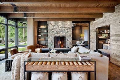 Example of a large mountain style open concept dark wood floor and brown floor living room design in Seattle with a standard fireplace, a stone fireplace and no tv