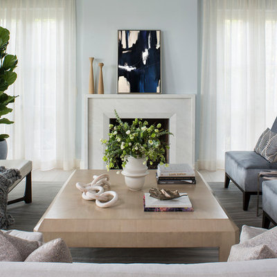 Example of a mid-sized beach style formal and open concept light wood floor living room design in Los Angeles with blue walls, a standard fireplace, a plaster fireplace and no tv
