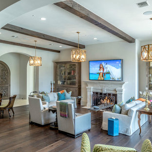 Living room - large southwestern open concept medium tone wood floor living room idea in Dallas with white walls, a standard fireplace, a stone fireplace and a wall-mounted tv