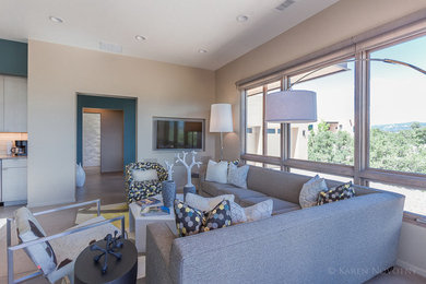 Immagine di un soggiorno design di medie dimensioni e aperto con pareti beige, pavimento in cemento e parete attrezzata