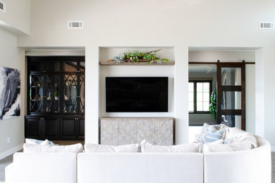 Living room - large mediterranean open concept gray floor and ceramic tile living room idea in San Luis Obispo with beige walls, a two-sided fireplace, a stone fireplace and a wall-mounted tv