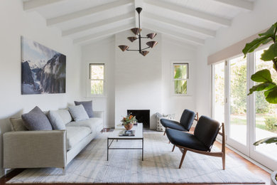 Mid-sized minimalist open concept brown floor and exposed beam living room photo in Los Angeles with white walls, a standard fireplace and a tile fireplace