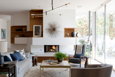Стильный дизайн: гостиная комната:: освещение в стиле модернизм с белыми стенами и стандартным камином - последний тренд