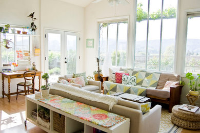 Living room - cottage medium tone wood floor living room idea in Santa Barbara with a music area and white walls