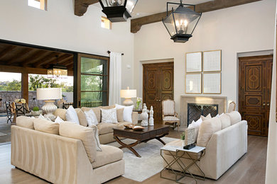 Example of a tuscan open concept and formal light wood floor and beige floor living room design in San Diego with a stone fireplace, white walls and a standard fireplace