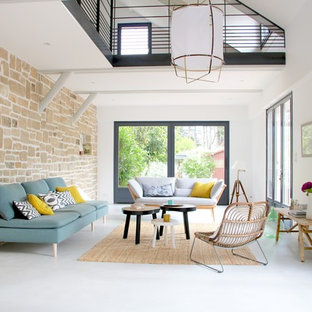Cette photo montre un grand salon scandinave ouvert avec un mur blanc, béton au sol, un sol gris, aucune cheminée et aucun téléviseur.