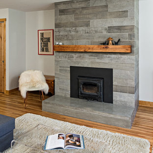 Living room - mid-sized scandinavian open concept medium tone wood floor living room idea in Minneapolis with white walls, a wood stove, a tile fireplace and a tv stand