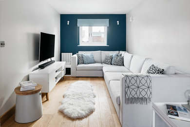 Aménagement d'un petit salon scandinave ouvert avec un mur gris et un téléviseur indépendant.