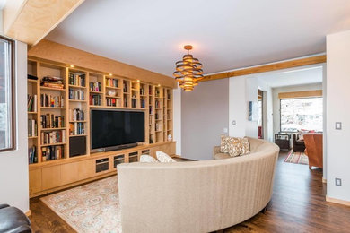 Ejemplo de salón abierto moderno de tamaño medio sin chimenea con paredes blancas, suelo de madera en tonos medios y pared multimedia
