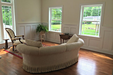 Example of a classic medium tone wood floor living room design in Philadelphia with no fireplace