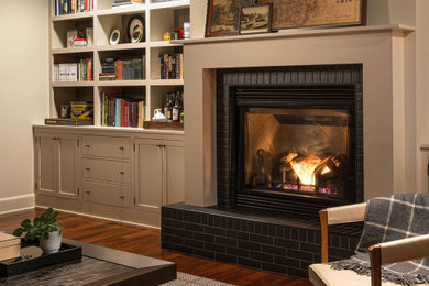 コロンバスにあるラグジュアリーな広いトラディショナルスタイルのおしゃれな独立型リビング (ライブラリー、標準型暖炉、レンガの暖炉まわり、埋込式メディアウォール、茶色い床) の写真