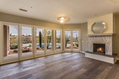 Großes, Fernseherloses, Offenes Modernes Wohnzimmer mit beiger Wandfarbe, braunem Holzboden, Kamin, gefliester Kaminumrandung und braunem Boden in Phoenix