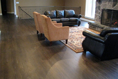 Example of a mid-sized mountain style open concept dark wood floor living room design in Toronto with brown walls, a standard fireplace, a stone fireplace and no tv