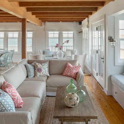 Example of a beach style open concept medium tone wood floor living room design in Boston with white walls