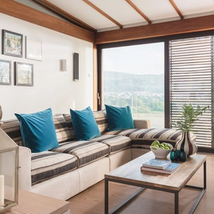 Small nautical living room in Other with light hardwood flooring, white walls and brown floors.