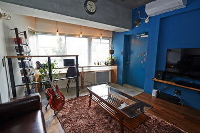 横浜にある広いインダストリアルスタイルのおしゃれなLDK (ミュージックルーム、青い壁、濃色無垢フローリング、暖炉なし、据え置き型テレビ、茶色い床) の写真