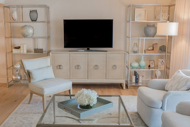 Example of a large transitional enclosed light wood floor and beige floor living room design in Miami with white walls, no fireplace and a tv stand