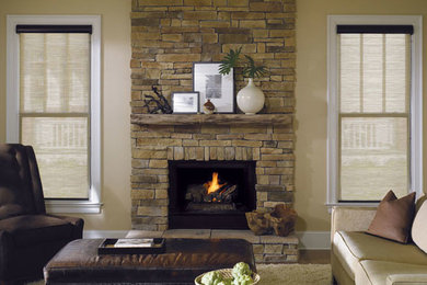 バンクーバーにある中くらいなトランジショナルスタイルのおしゃれなリビング (ベージュの壁、淡色無垢フローリング、標準型暖炉、石材の暖炉まわり) の写真