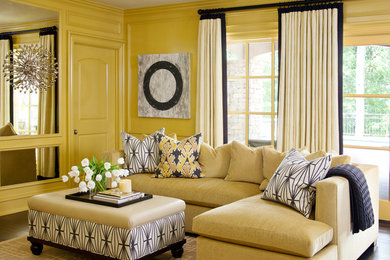 Cette image montre un grand salon gris et jaune traditionnel fermé avec un mur jaune, aucune cheminée, un téléviseur fixé au mur et parquet foncé.