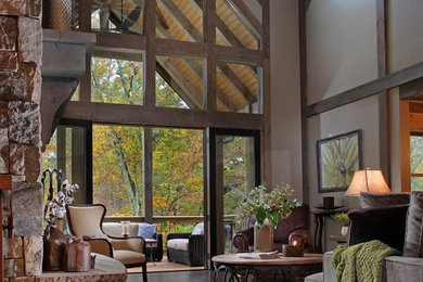 Example of a large mountain style formal and open concept dark wood floor and brown floor living room design in Atlanta with beige walls, a standard fireplace and a stone fireplace