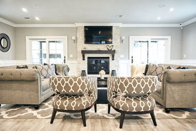 Inspiration for a large transitional open concept light wood floor and brown floor living room remodel in New York with gray walls, a standard fireplace, a tile fireplace and a wall-mounted tv