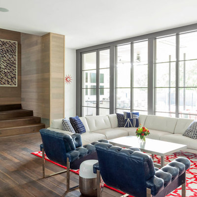 Example of a trendy formal and open concept medium tone wood floor living room design in Dallas with white walls and no tv
