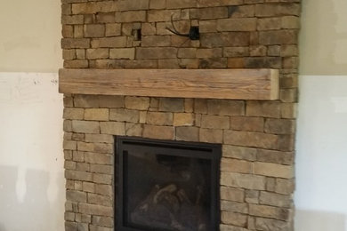 Inspiration for a rustic living room remodel in Kansas City with a stone fireplace